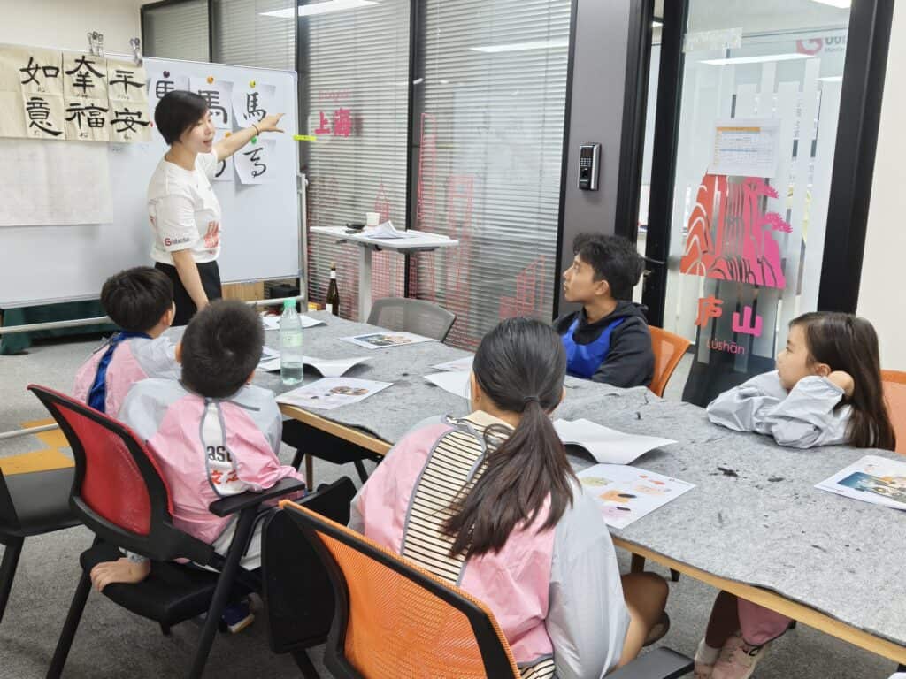 Children practicing calligraphy at GoEast Kids camp in Shanghai