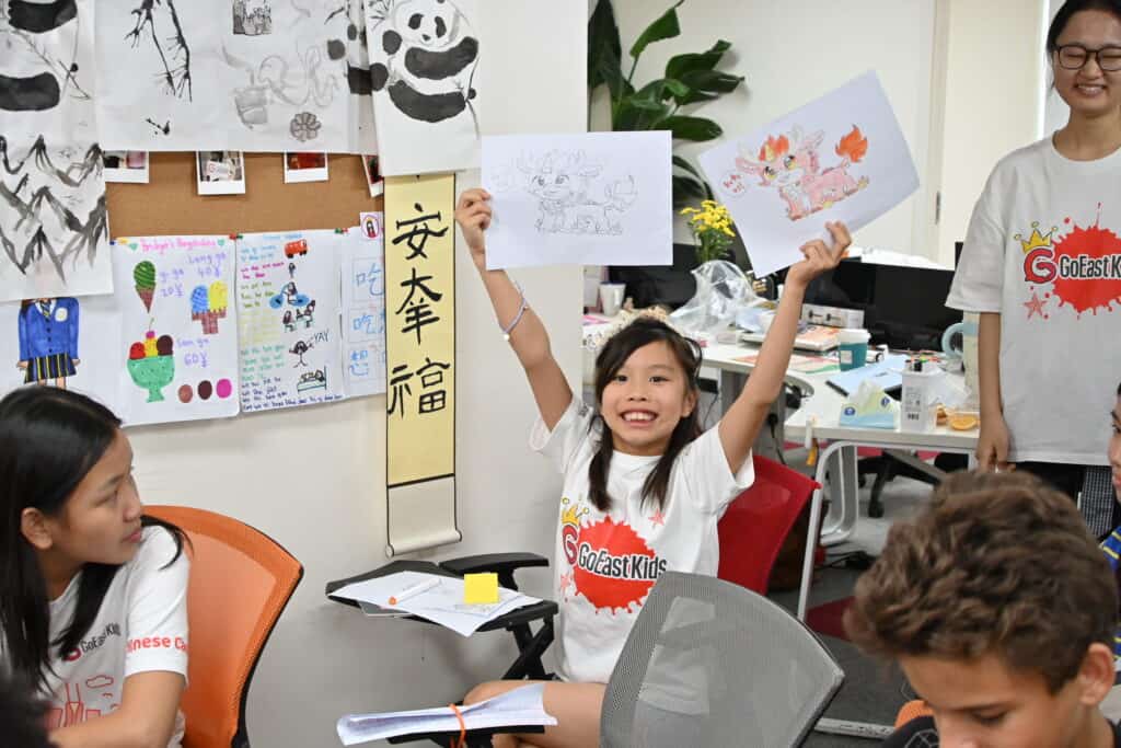 A camper showing her ink painting at GoEast Kids camp